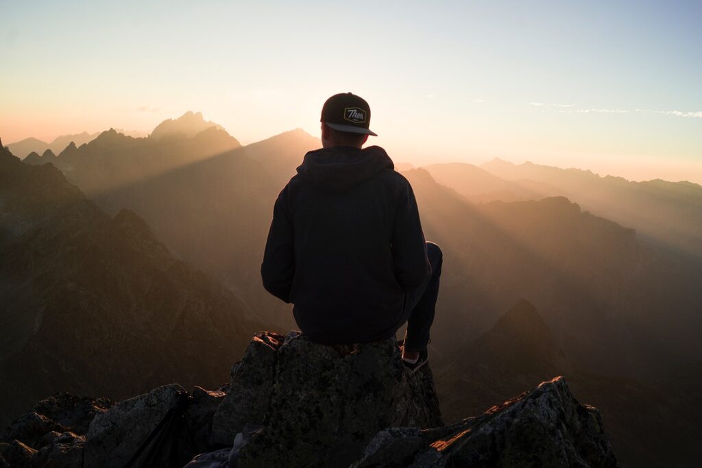 Man sitting on stone in mountains