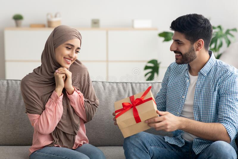 Husband giving present to her wife on her birthday.