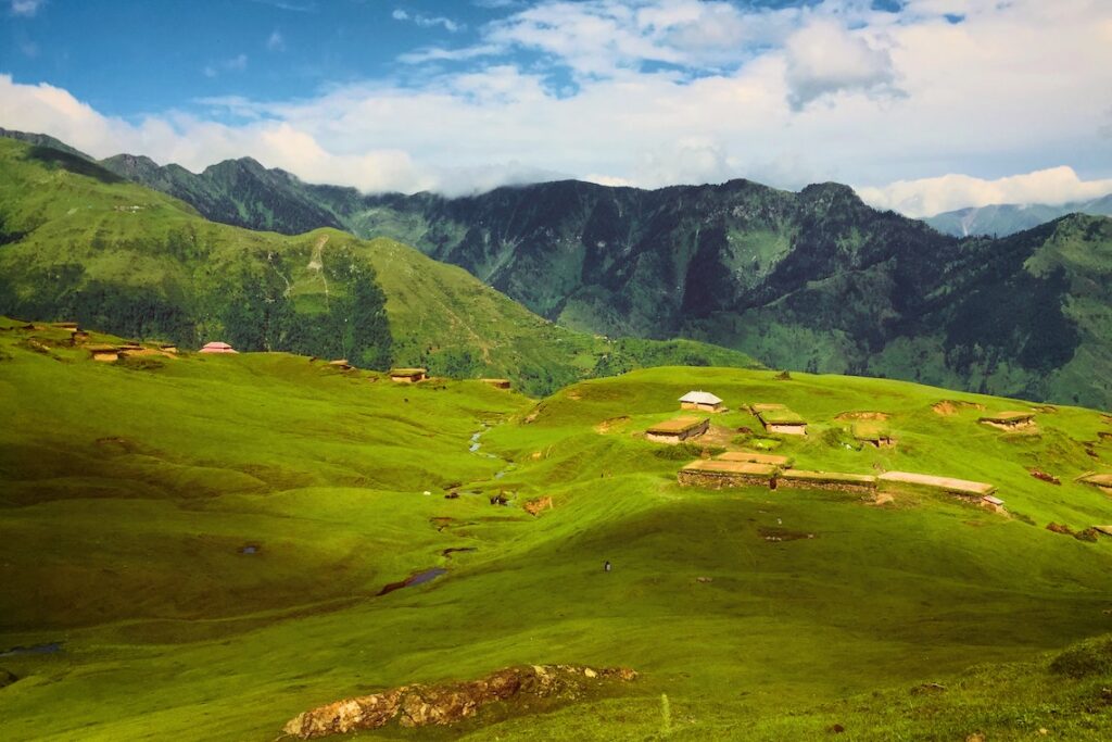 Green Pasture Land Having Huts.