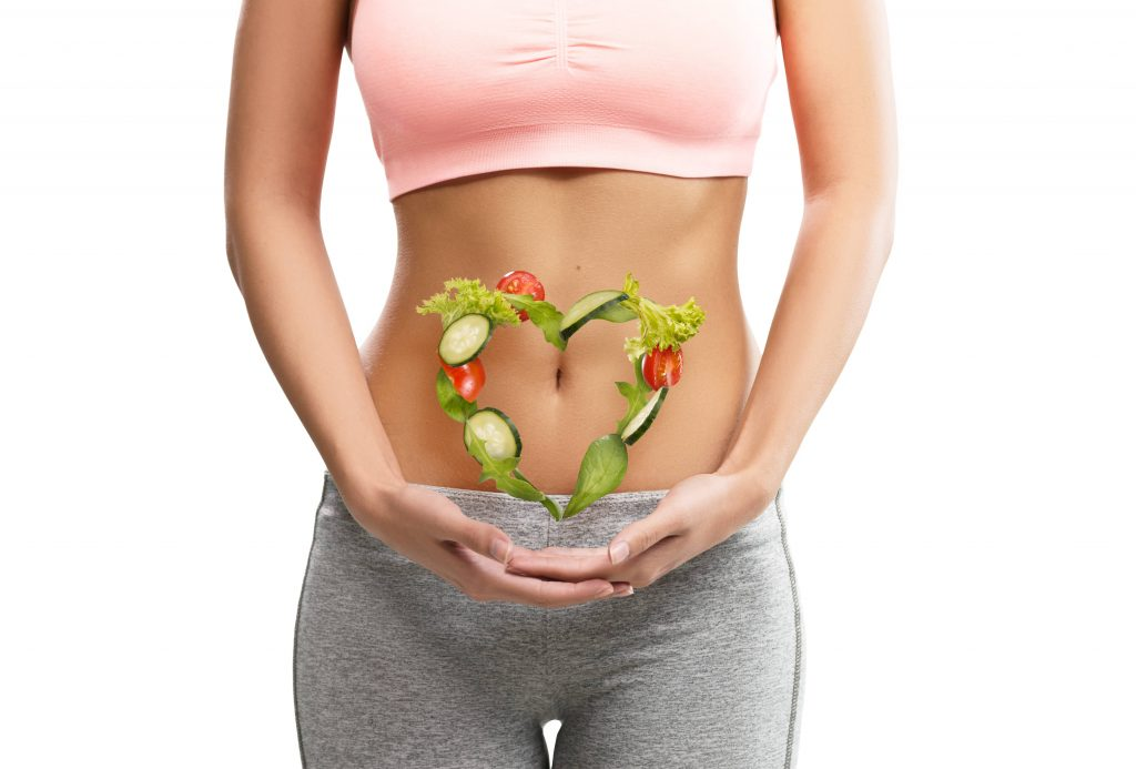 A woman indicating towards her healthy stomach.