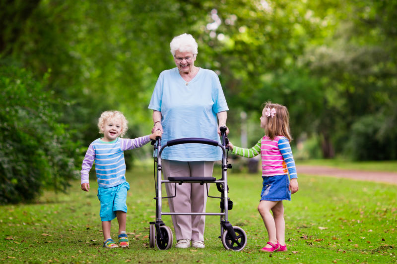 An elderly woman being helped by her grand children.