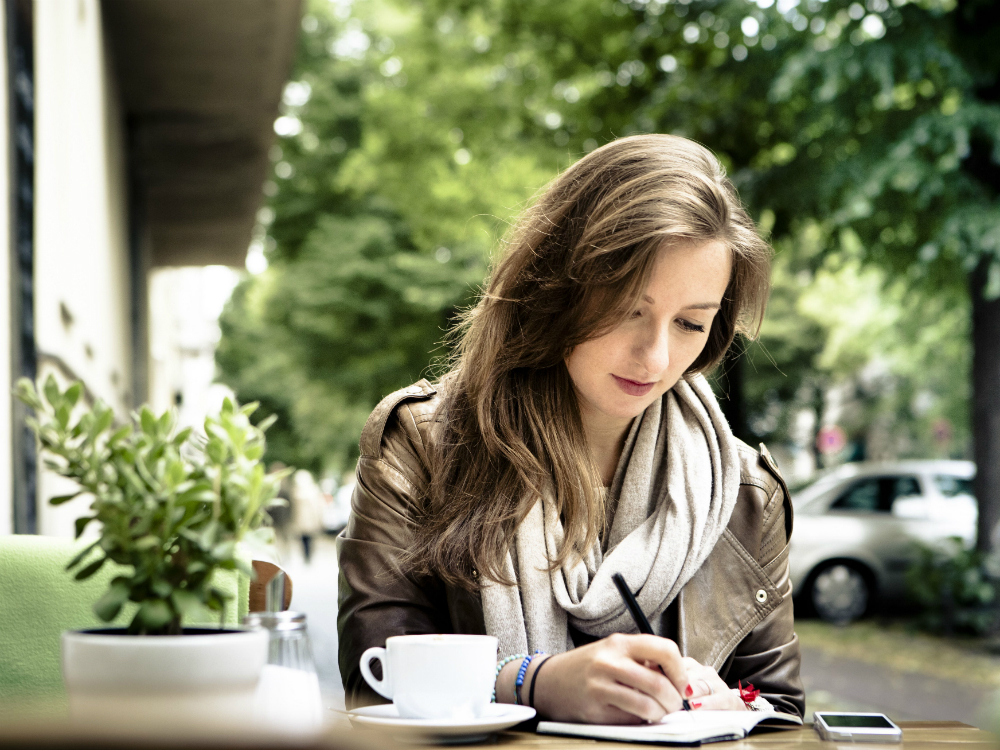 A woman writing a book.