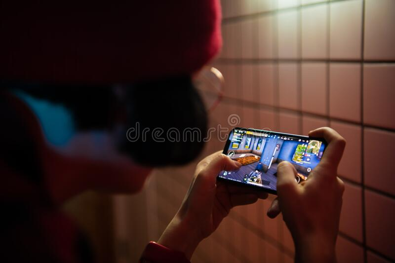 A boy playing game in his mobile.