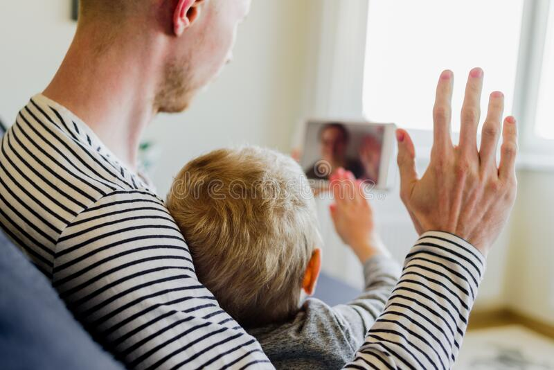 A son along with his father is  on a video call.