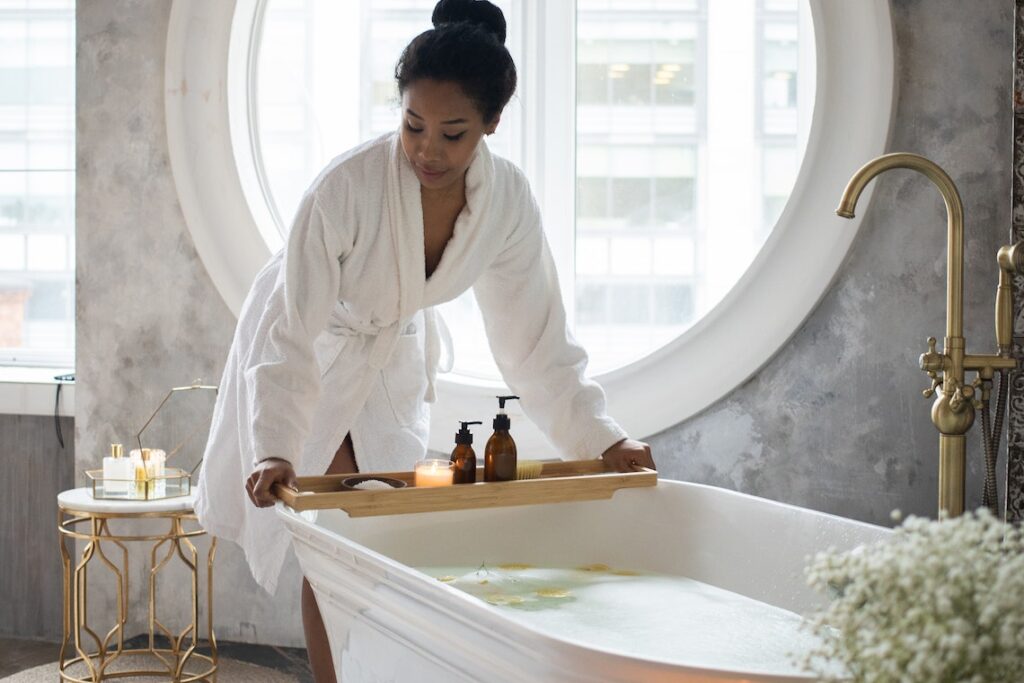 Black woman preparing for bath in Luke warm water.