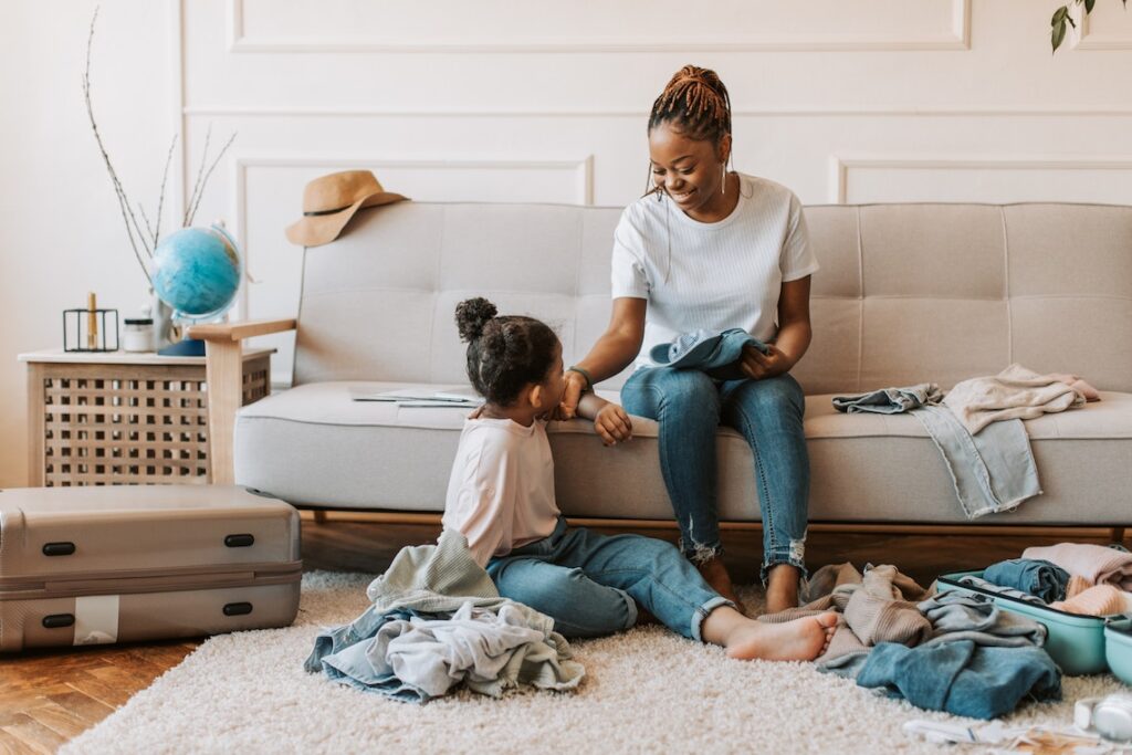 A girl and her mother packing for a trip.