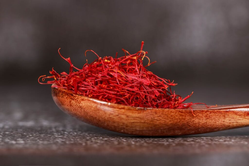 Saffron threads in a wooden spoon.