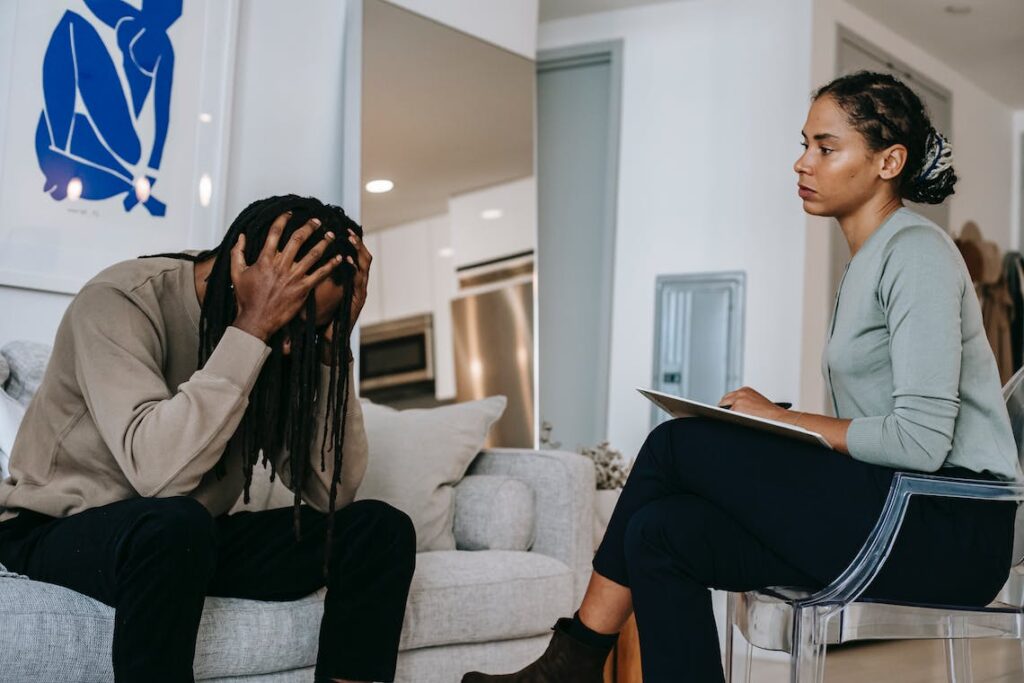 Overwhelmed black man discussing with a lady.